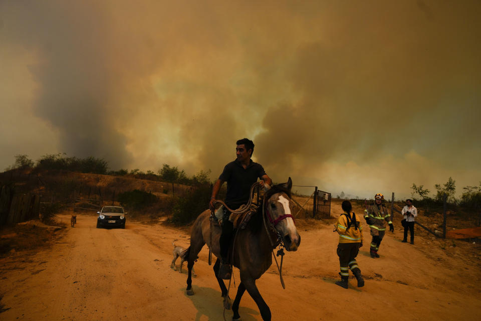 Un residente huye de un incendio en Viña del Mar, Chile, el 3 de febrero de 2024. Los letales incendios se originaron en la víspera en el extremo oriental del balneario costero. (AP Foto/Esteban Félix)