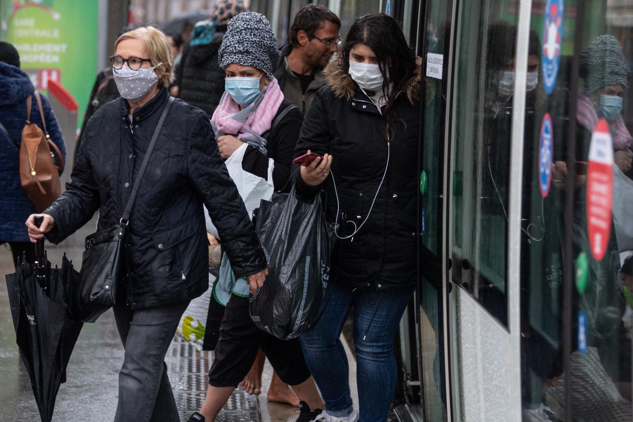 Passengers wearing a protective mask get out of a tram in central Strasbourg, eastern France, on May 11, 2020, on the first day of France's easing of lockdown measures in place for 55 days to curb the spread of the COVID-19 pandemic, caused by the new coronavirus. (Photo by PATRICK HERTZOG / AFP) (Photo by PATRICK HERTZOG/AFP via Getty Images)