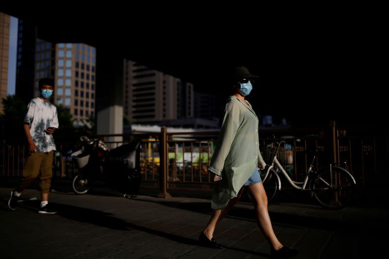 FILE PHOTO: People wearing face masks following the coronavirus disease (COVID-19) outbreak walk under an overpass in Beijing