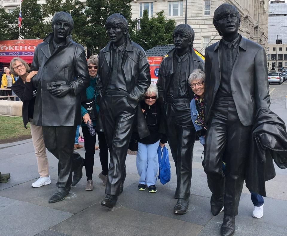 Judy Urban, from left, Loine Hockman, Bonnie Howe and Karen Konopka pose with the bronze statues of The Beatles during a trip to Liverpool, England for their 70th birthdays.
