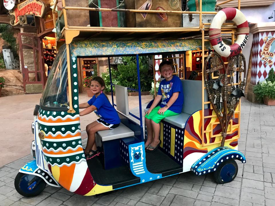 The author's kids on a colorful vehicle at Universal Studios.