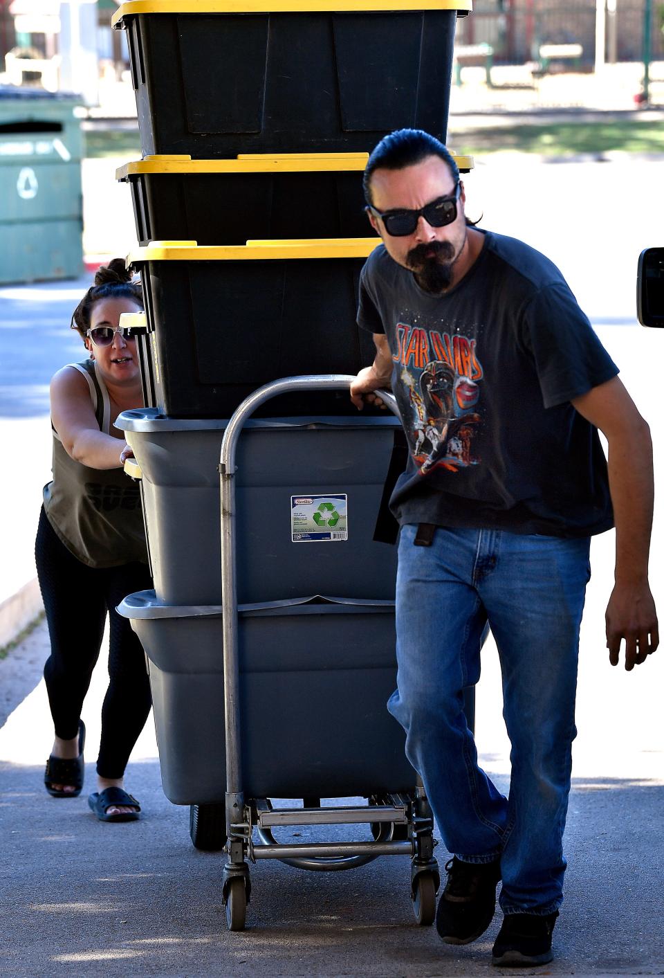 Cory Reyna and Cindi Herrera pull into the Abilene Convention Center a dolly loaded with merchandise from their Big Spring store, Cool Man Collectibles, Friday.