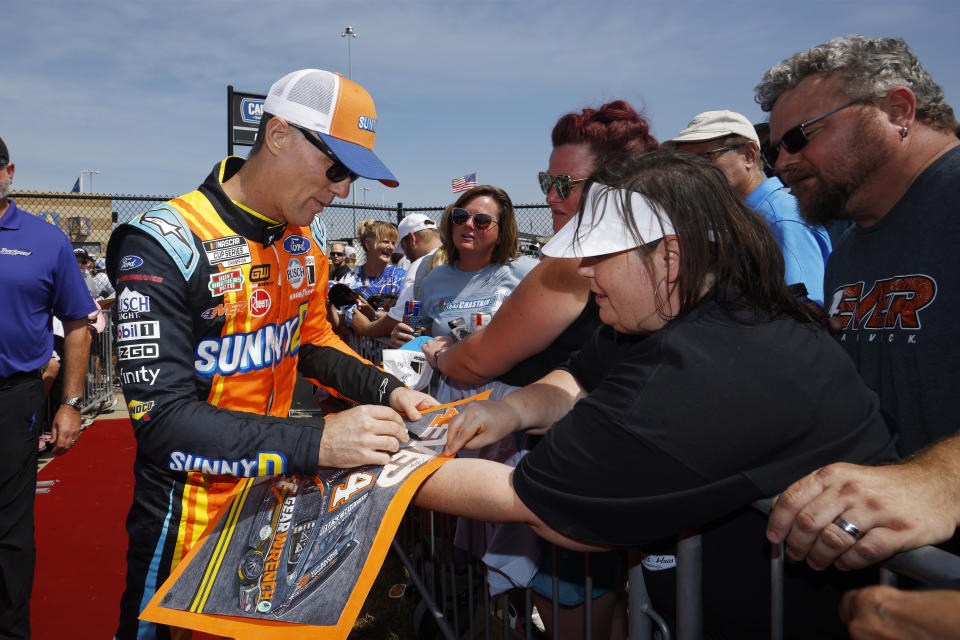 Kevin Harvick signs autographs before a NASCAR Cup Series auto race at Kansas Speedway in Kansas City, Kan., Sunday, Sept. 10, 2023. (AP Photo/Colin E. Braley)