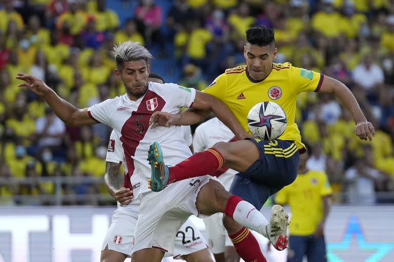 Colombia's Radamel Falcao Rodriguez, right, and Peru's Carlos Zambrano battle for the ball during a qualifying soccer match for the FIFA World Cup Qatar 2022 at Roberto Melendez stadium in Barranquilla, Colombia, Friday, Jan. 28, 2022. (AP Photo/Fernando Vergara)