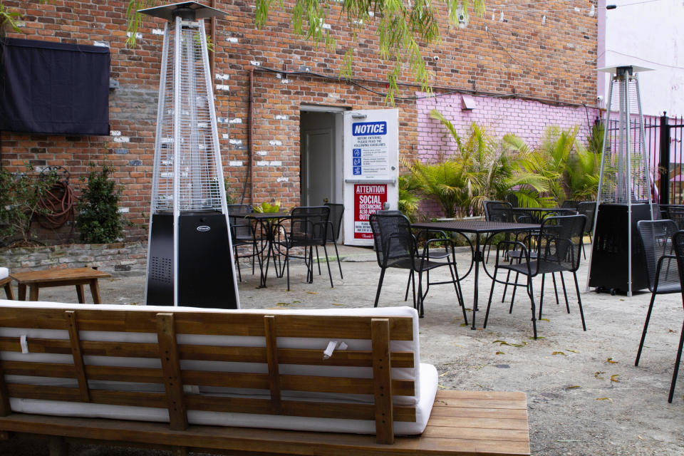 An outdoor seating area is seen at the NOLA Art Bar in New Orleans, Saturday, Jan. 30, 2021. DJ Johnson’s business — NOLA Art Bar — opened just six weeks before the pandemic-related shutdowns last March. It's been a struggle, but he’s still open nearly a year later. (AP Photo/Dorthy Ray)