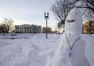 A snowman with a pretend NSA (National Security Agency) badge and a coffee cup stands in Lafayette Square Park, across from the White House in Washington, Monday, Jan. 25, 2016. [AP Photo/Carolyn Kaster]