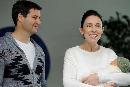 FILE PHOTO: New Zealand Prime Minister Jacinda Ardern carries her newborn baby Neve Te Aroha Ardern Gayford with her partner Clarke Gayford as she walks out of the Auckland Hospital in New Zealand, June 24, 2018. REUTERS/Ross Land/File Photo