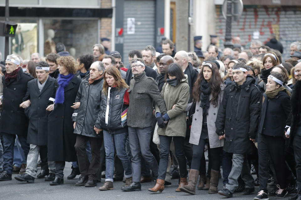 Charlie Hebdo newspaper staff, with cartoonist Renald Luzier, known as Luz, at center with moustache, march in Paris, France, Sunday, Jan. 11, 2015. (AP Photo/Francois Mori)