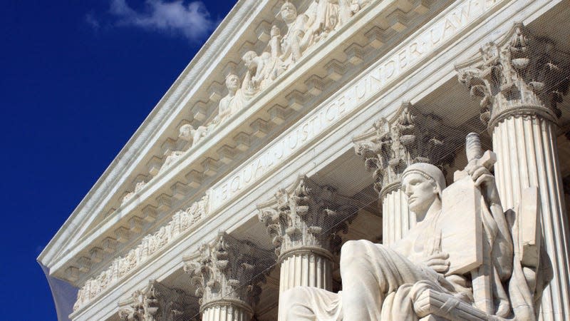 The outside of the Supreme Court building with statue out front.