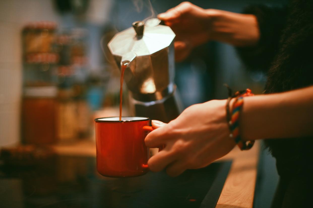 A woman’s hands while she’s pouring coffee into a cup (Getty Images)