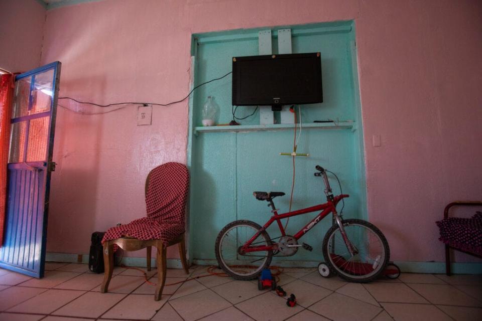 A bicycle rests against a wall in the living area of one apartment within a migrant shelter in Anapra.