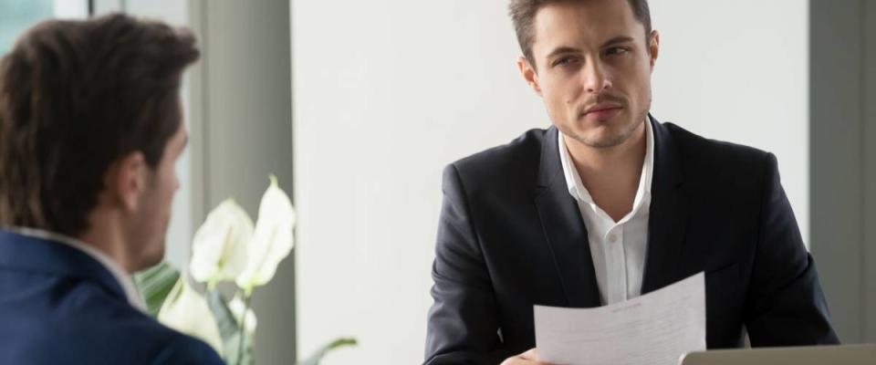 Distrustful businessman holding document at meeting, looking at partner with doubt suspicion