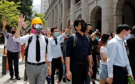 Anti-government office workers wearing masks attend a lunch time protest, after local media reported on an expected ban on face masks under emergency law, at Central, in Hong Kong