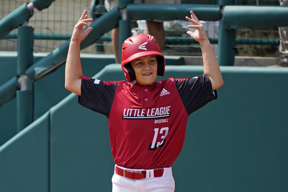 Hamilton, Ohio's Maddox Jones (13) celebrates as he stands on first base after driving in a run with a single off Sioux Falls, S.D's Brekken Biteler (5) during the fifth inning of a baseball game at the Little League World Series in South Williamsport, Pa., Saturday, Aug. 28, 2021. (AP Photo/Gene J. Puskar)