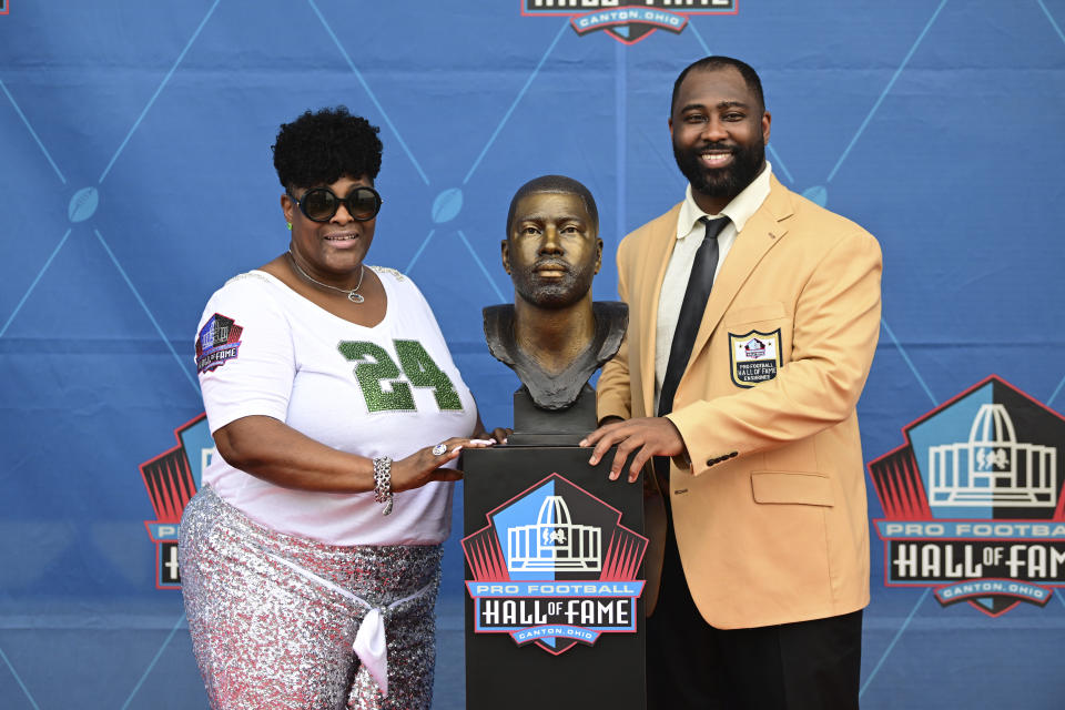 Former NFL player Darrelle Revis, right, and his mother Diana Gilbert pose with his bust during his induction into the Pro Football Hall of Fame in Canton, Ohio, Saturday, Aug. 5, 2023. (AP Photo/David Dermer)