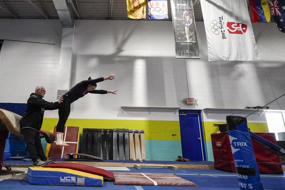 Former world champion and Olympic silver medalist Chellsie Memmel works out with her father and coach Andy Memmel Thursday, Feb. 18, 2021, in New Berlin, Wisc. (AP Photo/Morry Gash)