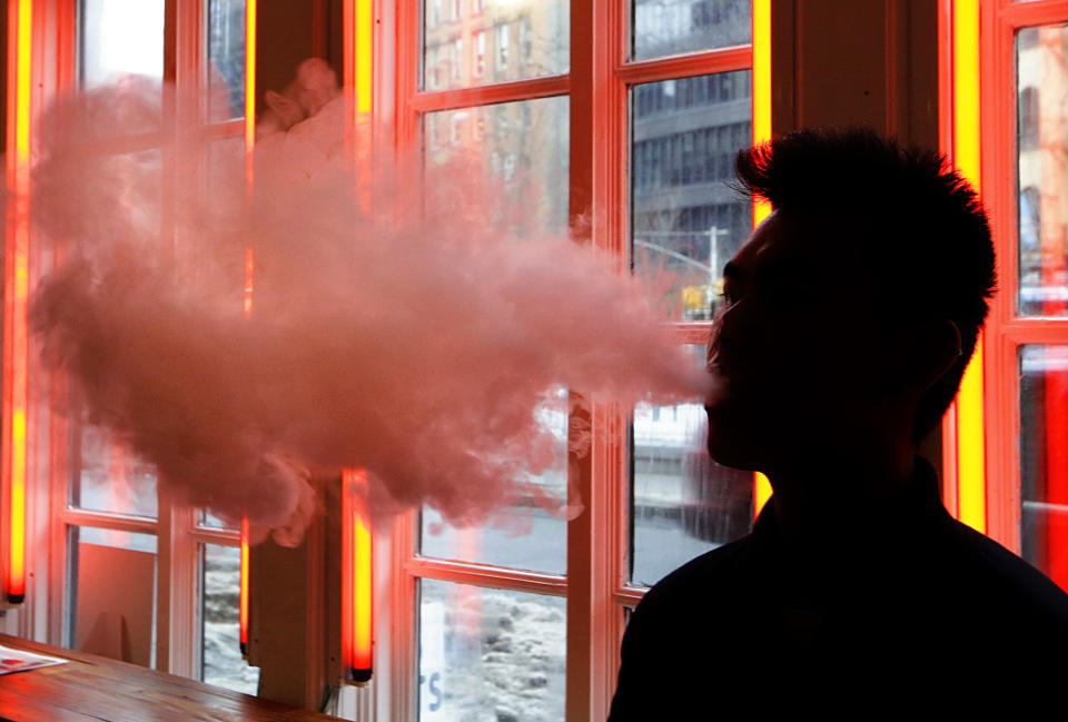 FILE - In this Feb. 20, 2014, file photo, a patron exhales vapor from an e-cigarette at a store in New York. Under the Trump administration, former FDA commissioner Scott Gottlieb kicked off his tenure in 2017 with the goal of making cigarettes less addictive by drastically cutting nicotine levels. He also rebooted the agency’s effort to ban menthol flavoring in cigarettes. But those efforts have been largely eclipsed by the need to respond to an unexpected explosion in e-cigarette use by teens. (AP Photo/Frank Franklin II, File)