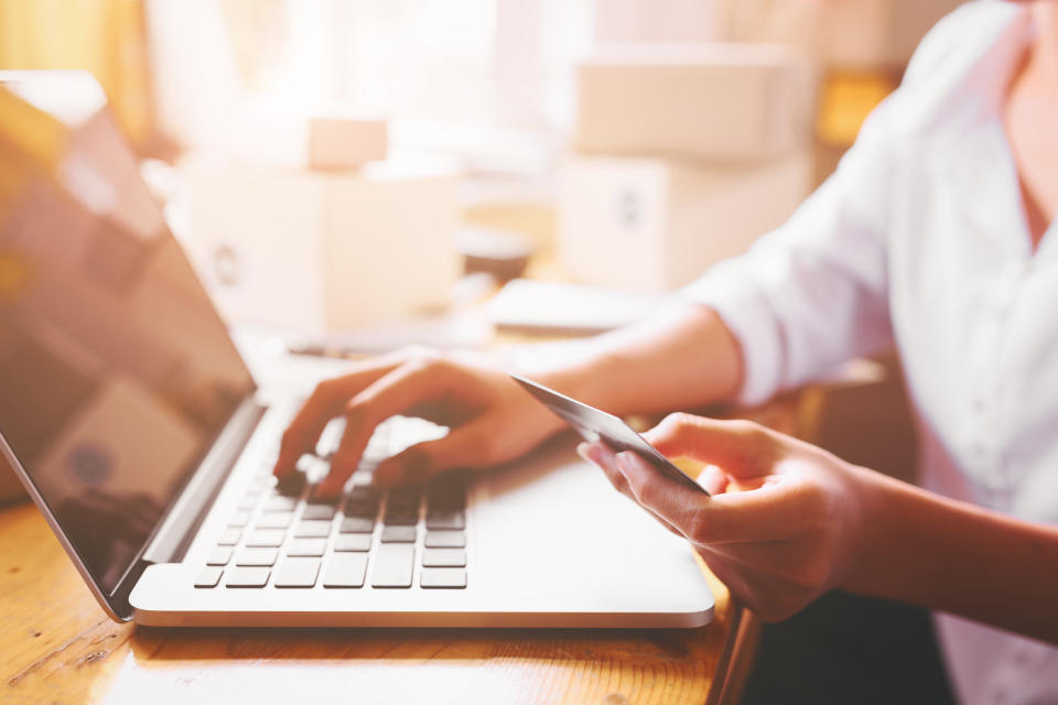 Woman at laptop holding credit card