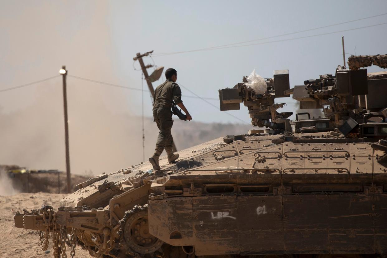 An Israeli soldier walks on a tank near the border with the Gaza Strip on August 21, 2024 in Southern Israel, Israel. US Secretary of State, Antony Bliken, has said that "time is of the essence" in the ceasefire talks between Israel and Hamas with an agreement still to be reached.