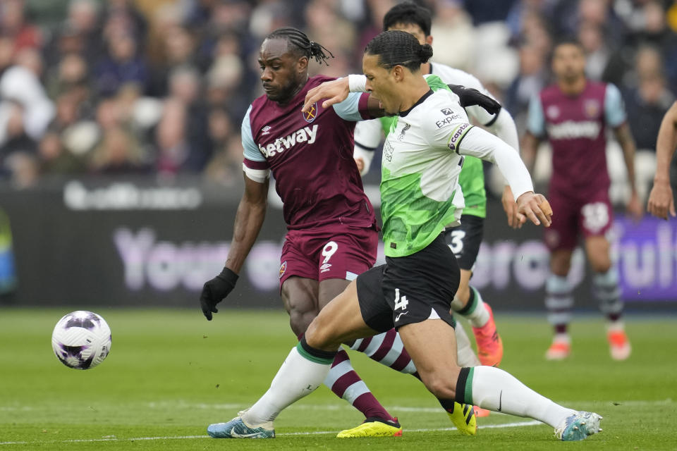 West Ham's Michail Antonio, left, and Liverpool's Virgil van Dijk battle for the ball during the English Premier League soccer match between West Ham United and Liverpool at London stadium in London, Saturday, April 27, 2024. (AP Photo/Kin Cheung)