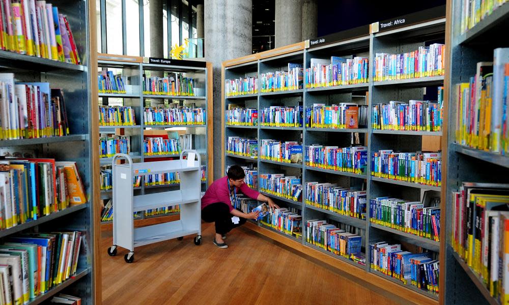 A librarian files books in a public library