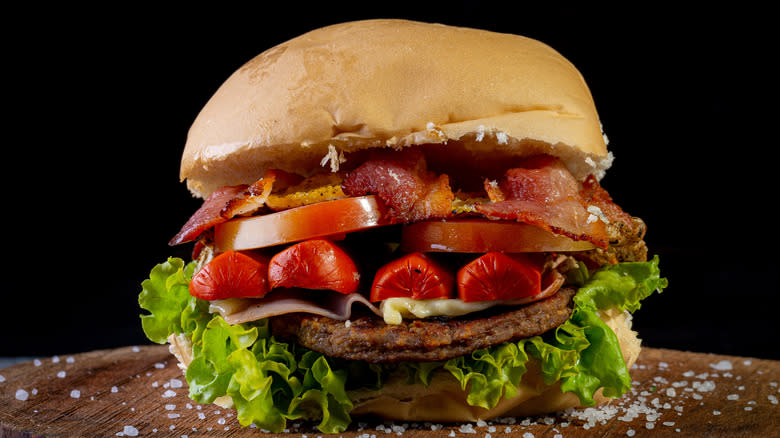 Burger on wooden board sprinkled with salt