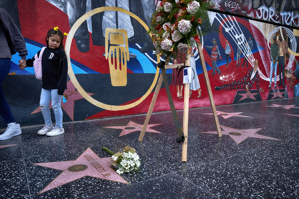 A tourist looks at a memorial wreath that was placed on the Hollywood Walk of Fame star for Louis Gossett Jr., on Friday, March 29,2024. Gossett was the first Black man to win a supporting actor Oscar and an Emmy winner for his role in the seminal TV miniseries "Roots," has died. He was 87. (AP Photo/Richard Vogel)