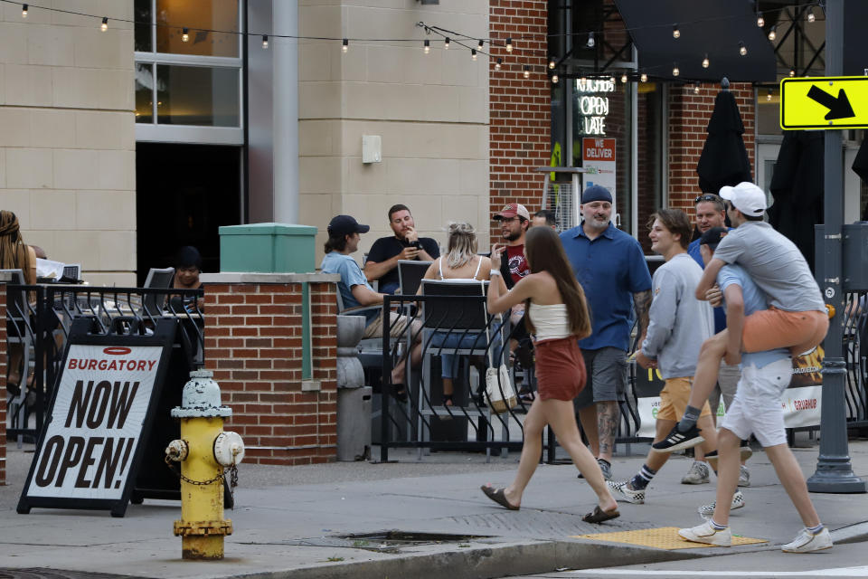 FILE - In this June 28, 2020, file photo, people gather at tables outside Bar Louie on the Northside of Pittsburgh. Authorities are closing honky tonks, bars and other drinking establishments in some parts of the U.S. to stem the surge of COVID-19 infections — a move backed by sound science about risk factors that go beyond wearing or not wearing masks. (AP Photo/Gene J. Puskar, File)