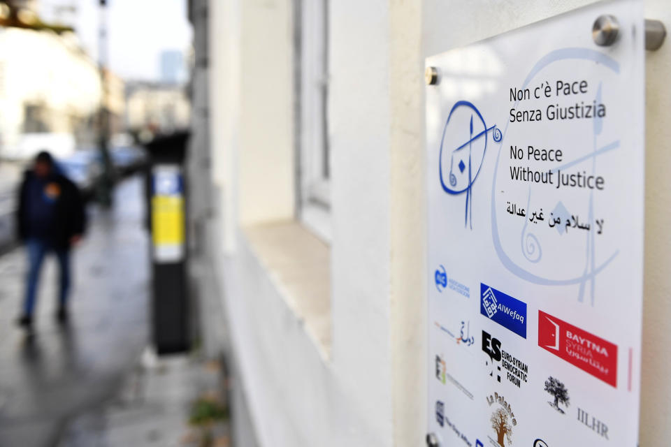 A man walks by the office of Belgian NGO 'No Peace without Justice' in Brussels, Friday, Dec. 16, 2022. No one answers the door buzzer at the offices of the two campaign groups linked to a cash-for-influence corruption scandal at the European Union's parliament, allegedly involving Qatari officials. No obvious light shines on what goes on inside their premises. (AP Photo/Geert Vanden Wijngaert)