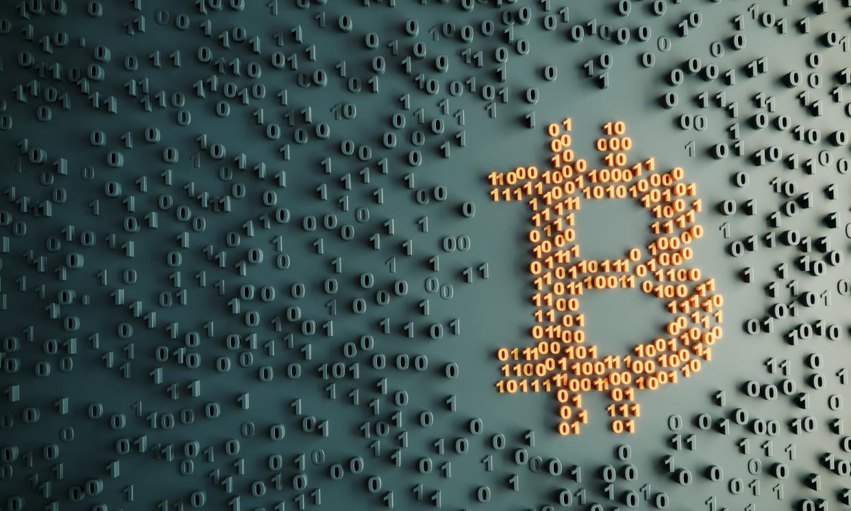 Símbolo de bitcoin con códigos binarios (Foto: Getty)