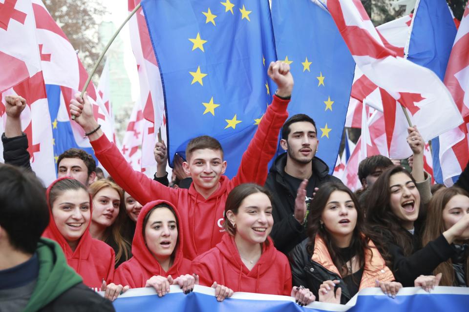 Georgians with EU and national flags gather to celebrate Georgia's EU candidacy at the Rustaveli street in Tbilisi, Georgia, on Friday, Dec. 15, 2023. Several thousand people attend a march in support of Georgia's EU candidacy. European Union flags waved across Georgia Friday after the European Council took a step forward along the long road towards granting Georgia and Moldova as EU membership. (AP Photo/Zurab Tsertsvadze)