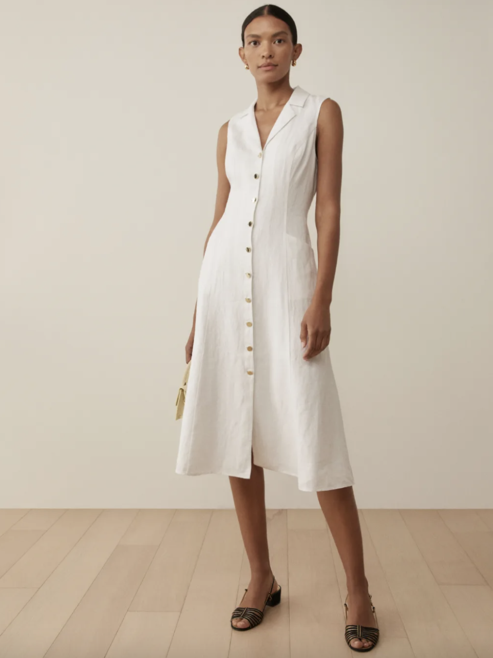 model with slicked back hair and black sandals in white sleeveless Greene Linen Dress (Photo via Reformation)