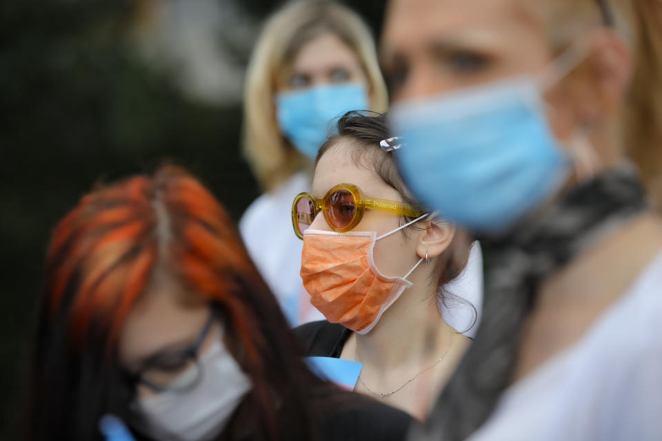 Protesters wear protective face masks outside the presidential palace in Bucharest, Romania, Thursday, June 18, 2020, during a rally against a law banning the teaching of gender studies. Dozens of protesters gathered outside Bucharest's Cotroceni Presidential Palace, to express their opposition to a law banning the teaching of gender studies in the country's schools and universities and call on President Klaus Iohannis to reject signing the bill and send it back to parliament. (AP Photo/Vadim Ghirda)