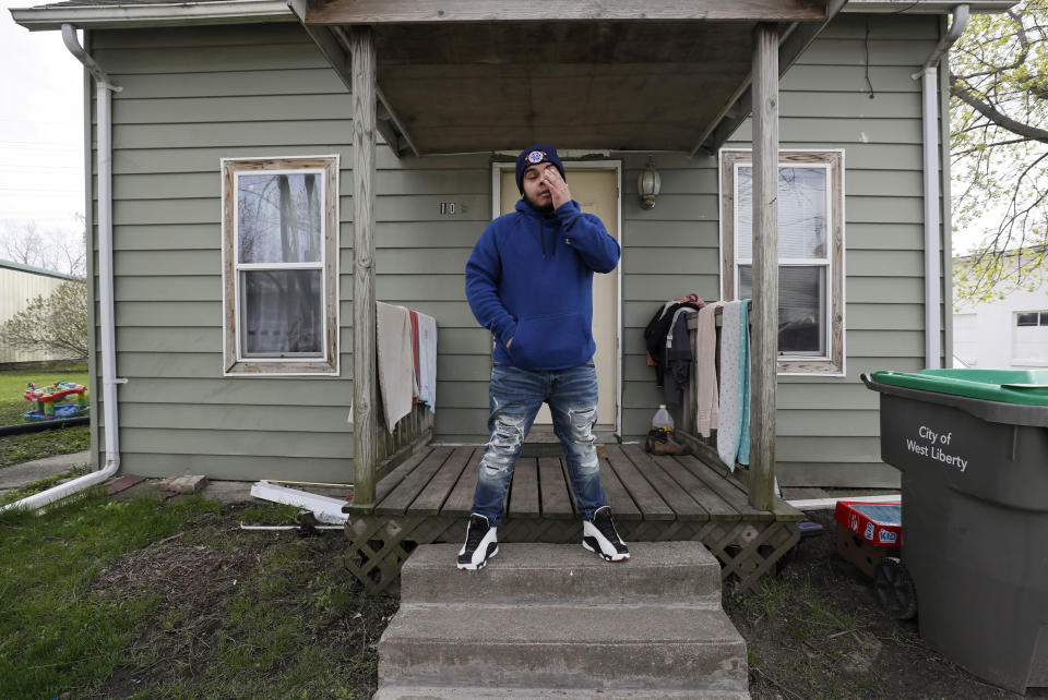 Omar Martinez talks about how the coronavirus has affected his family as he stands on the front porch of the family home, Saturday, April 25, 2020, in West Liberty, Iowa. (AP Photo/Charlie Neibergall)