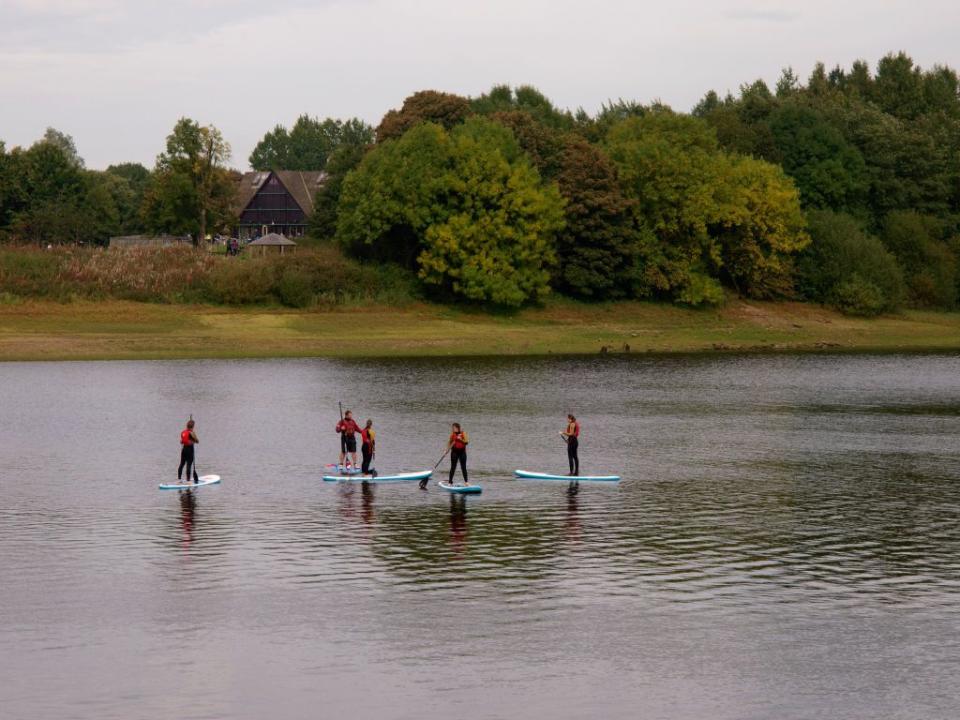 visit peak district   people learning to stand up paddle board on tittesworth water reservoir, uk