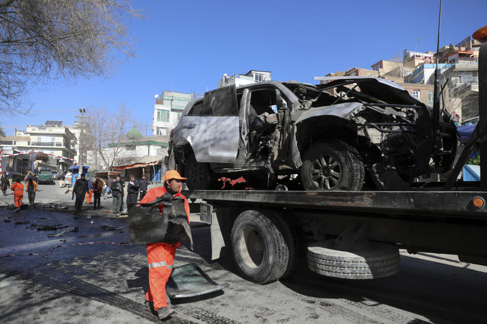 Afghan security personnel remove a damaged vehicle after a bomb attack in Kabul, Afghanistan, Saturday, Jan. 16, 2021. A sticky bomb attached to an armored police Land Cruiser SUV exploded Saturday in the western part of the capital, Kabul, killing few policemen and wounding another, Kabul police spokesman Ferdaws Faramarz said. (AP Photo/Rahmat Gul)