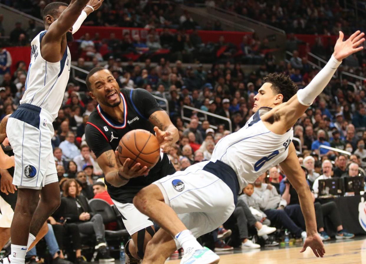 Clippers' Norman Powell gets fouled by Dallas Mavericks Josh Green during fourth-quarter play.