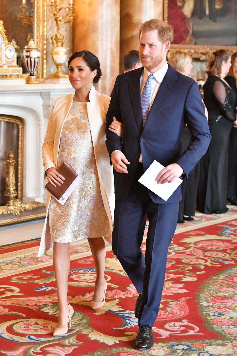 For a March reception at Buckingham Palace to mark the 50th anniversary of the investiture of the Prince of Wales, Meghan wore her trusty Amanda Wakeley white coat over a metallic brocade knee-length dress for the perfect hint of daytime elegance.