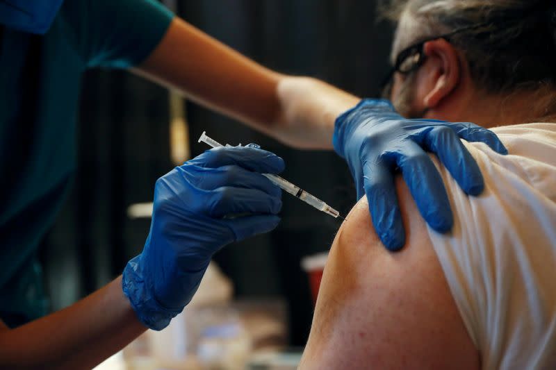 FILE PHOTO: A Metropolitan Transportation Authority (MTA) worker receives the Pfizer COVID-19 vaccination for MTA employees at Vanderbilt Hall at Grand Central Terminal in the Manhattan borough of New York