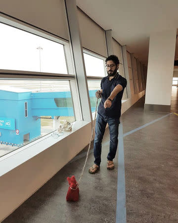 Syrian refugee Hassan Al Kontar walks his stuffed pet "Miss Crimson" in Kuala Lumpur International Airport, where he was stranded for seven months, in Kuala Lumpur, Malaysia, August 4, 2018. Courtesy of Hassan Al Kontar/Handout via REUTERS