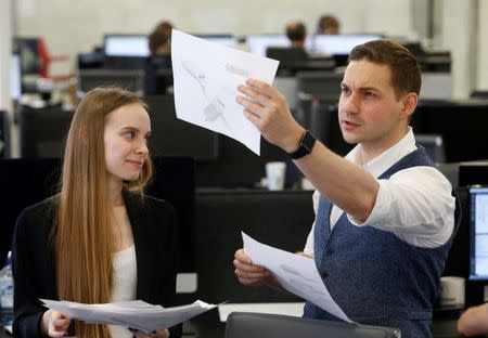 Vitaly Ponomarev (R), entrepreneur and founder of WayRay innovative high-tech company, talks to an employee while posing for a picture at the company's office in Moscow, Russia, July 6, 2016. REUTERS/Sergei Karpukhin