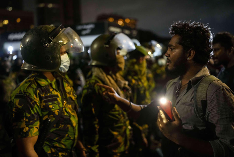 A protester tries to speak with an army officer at the site of a protest camp outside the Presidential Secretariat in Colombo, Sri Lanka, early Friday, July 22, 2022. (AP Photo/Rafiq Maqbool)