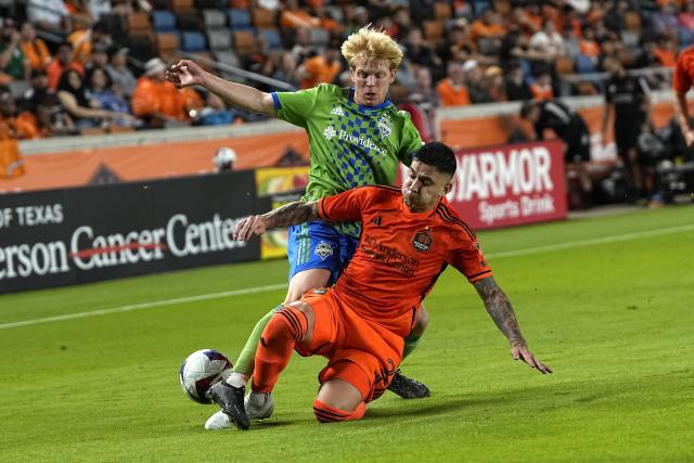 Houston Dynamo's Franco Escobar (2) knocks the ball from Seattle Sounders' Ethan Dobbelaere during the second half of an MLS soccer match Saturday, May 13, 2023, in Houston. (AP Photo/David J. Phillip)
