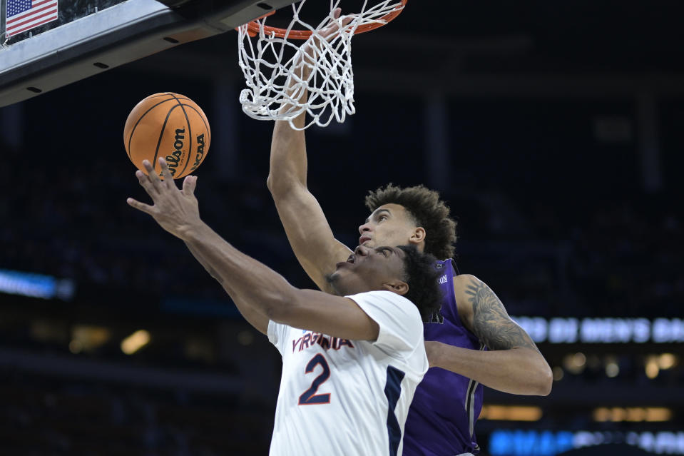 Virginia guard Reece Beekman (2) is fouled by Furman forward Jalen Slawson, rear, while going up for a shot during the first half of a first-round college basketball game in the NCAA Tournament, Thursday, March 16, 2023, in Orlando, Fla. (AP Photo/Phelan M. Ebenhack)