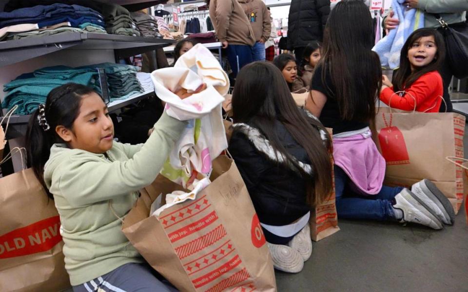 Los niños se reúnen para compartir la ropa que compraron después de una jornada de compras organizada por Live Again Fresno en Old Navy, la mañana del lunes 18 de diciembre de 2023, en Fresno. ERIC PAUL ZAMORA/ezamora@fresnobee.com