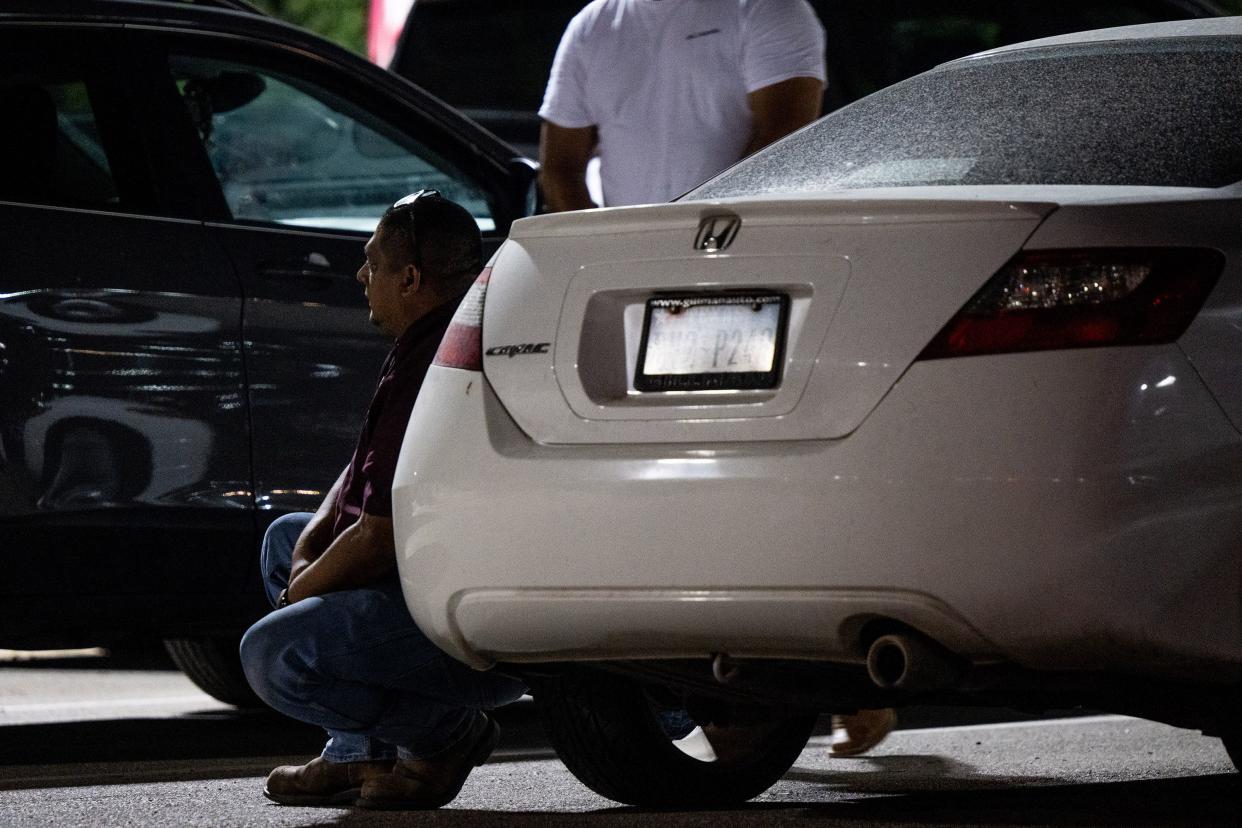 A person sits next to a vehicle outside of the SSGT Willie de Leon Civic Center following the mass shooting at Robb Elementary School on May 24, 2022, in Uvalde, Texas. According to reports, 19 students and 2 adults were killed, with the gunman fatally shot by law enforcement.