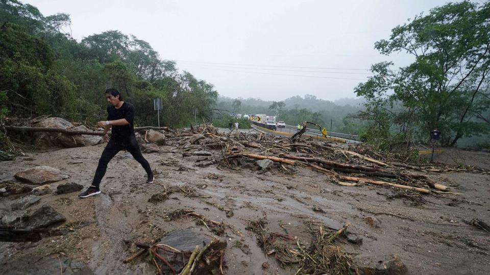 PHOTO: A man crosses a highway blocked by a landslide triggered by Hurricane Otis near Acapulco, Mexico, Wednesday, Oct. 25, 2023. (Marco Ugarte/AP)