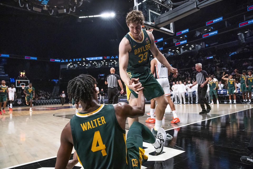 Baylor forward Caleb Lohner (33) helps Ja'Kobe Walter (4) up after a foul by Oregon State during the second half of an NCAA college basketball game Wednesday, Nov. 22, 2023, in New York. (AP Photo/Eduardo Munoz Alvarez)
