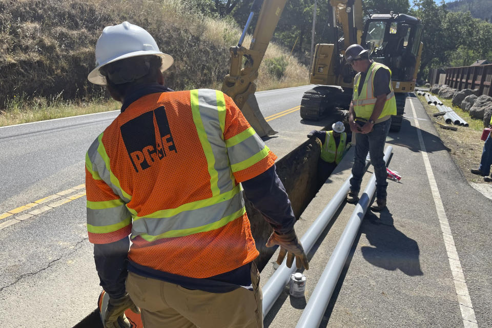 A PG&E crew works at installing underground power lines along Porter Creek Road in Sonoma County, Calif., site of the 2017 Tubbs Fire, on Monday, June 13, 2022. Pacific Gas & Electric Co. has started an ambitious project to bury thousands of miles of power lines underground in an effort to prevent igniting fires with its equipment and avoid shutting down power during hot and windy weather. (AP Photo/Haven Daley)