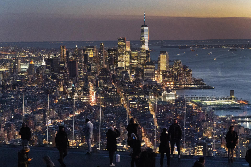 FILE - Visitors to the Edge, an outdoor observation deck 1100 feet above the ground, look at the lights of Manhattan, March 2, 2021, in New York. New York will lose one seat in Congress as a result of national population shifts, according to census data released Monday. (AP Photo/Mark Lennihan, File)